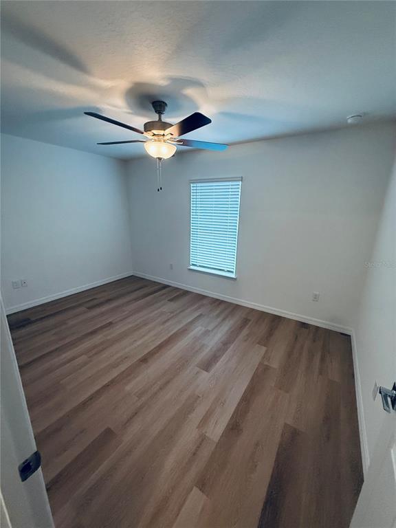 12 Slipper Flower Path East Palm Coast, FL 32164 - Photo 15 of 36 an empty room with a ceiling fan and wooden floor