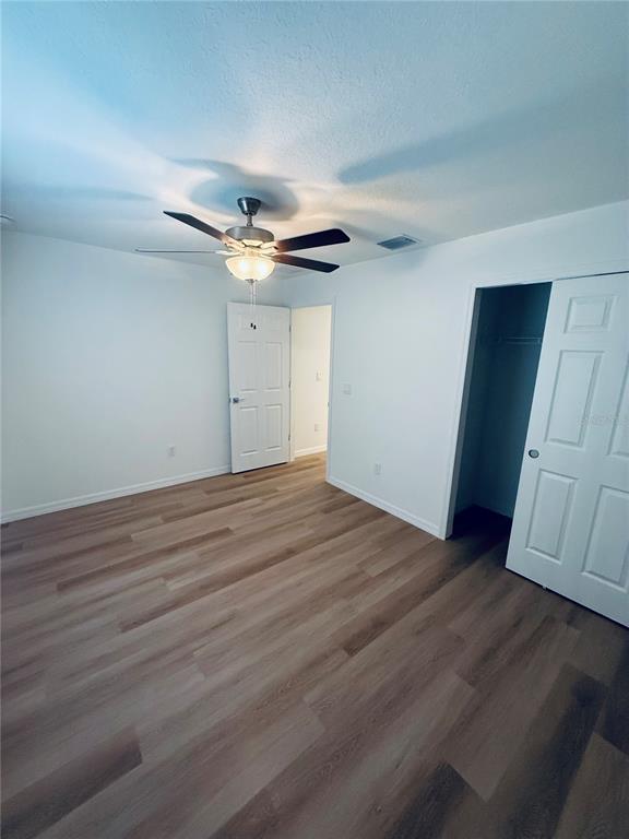 12 Slipper Flower Path East Palm Coast, FL 32164 - Photo 16 of 36 an empty room with wooden floor and a ceiling fan