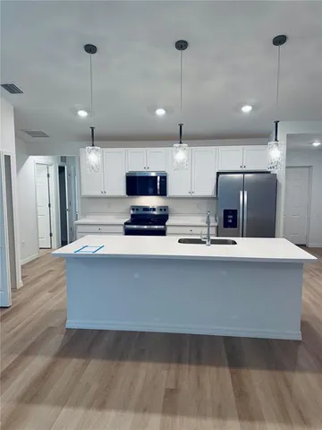 a large kitchen with kitchen island a refrigerator a center island a stove a center island a stove and cabinets