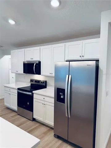 a kitchen with a refrigerator sink and cabinets