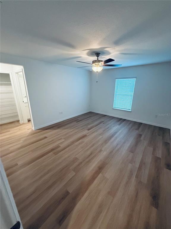 12 Slipper Flower Path East Palm Coast, FL 32164 - Photo 10 of 36 an empty room with wooden floor chandelier fan and windows