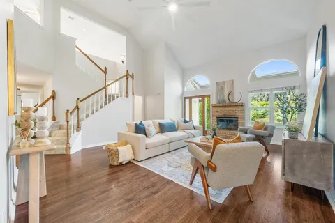 a living room with fireplace furniture and a large window