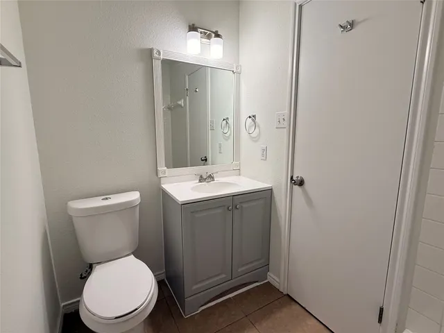a bathroom with a toilet a sink and mirror