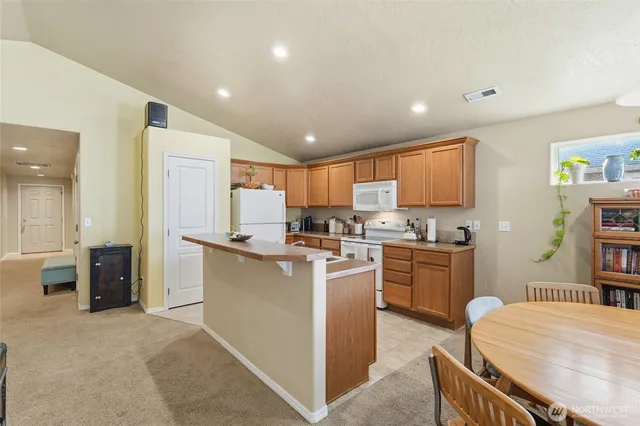 a kitchen with sink a refrigerator and wooden cabinets