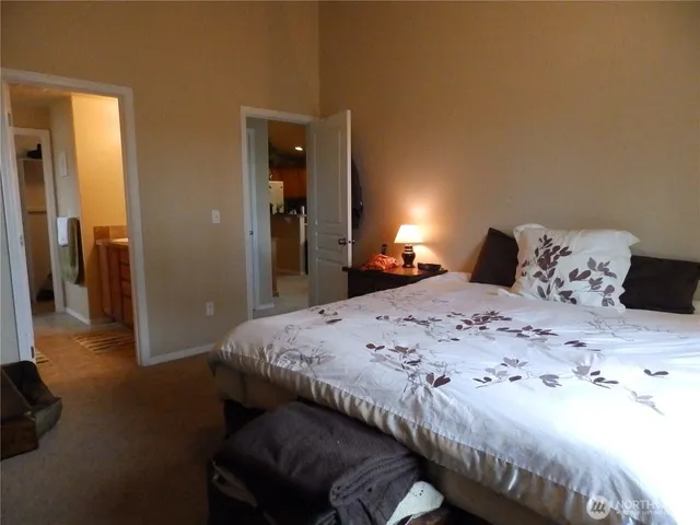 a bedroom with a bed and a large mirror