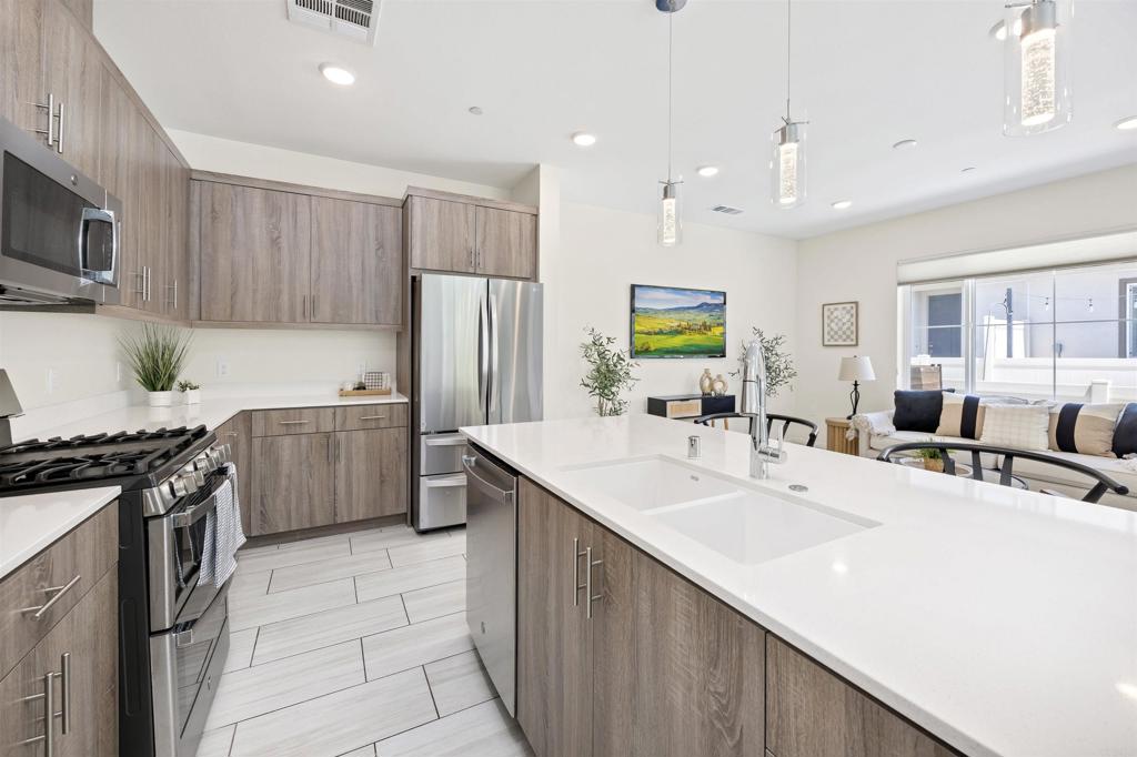 35103 Vine Place Fallbrook, CA 92028 - Photo 20 of 42 a kitchen with stainless steel appliances a sink a stove a refrigerator cabinets and a window