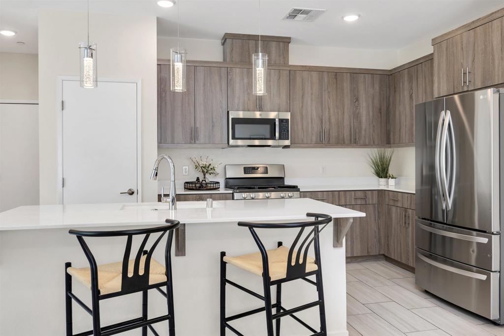 35103 Vine Place Fallbrook, CA 92028 - Photo 23 of 42 a kitchen with stainless steel appliances a stove a sink island and a refrigerator