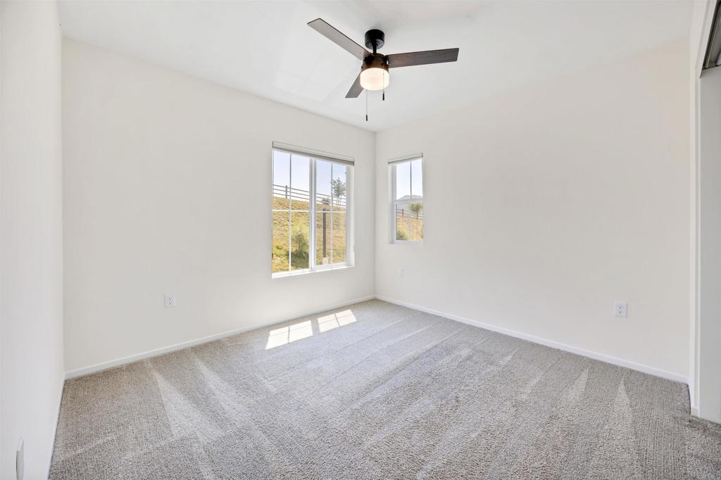 35103 Vine Place Fallbrook, CA 92028 - Photo 28 of 42 an empty room with windows and ceiling fan