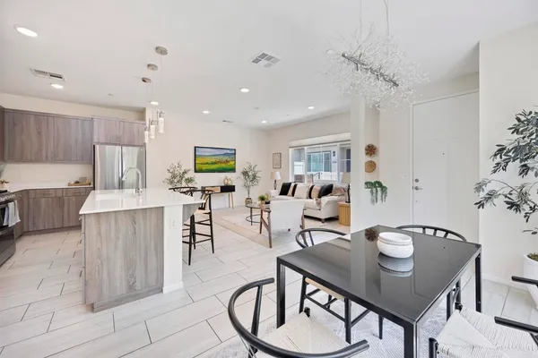 a living room with furniture and a dining table with kitchen view