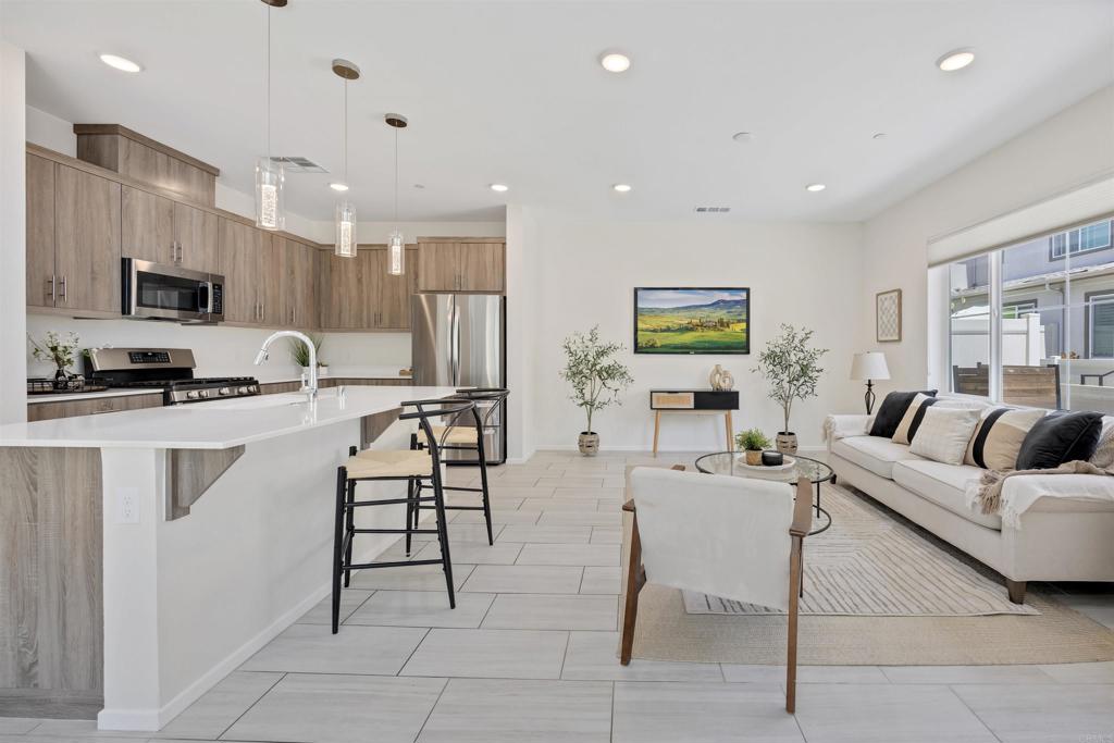 35103 Vine Place Fallbrook, CA 92028 - Photo 9 of 42 a living room with furniture a flat screen tv and kitchen view