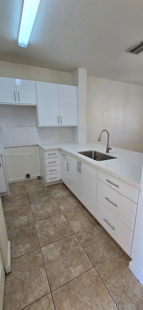 1480 Northeast 33rd Avenue, Unit 210 Homestead, FL 33033 - Photo 8 of 12 a kitchen with a stove a sink and cabinets