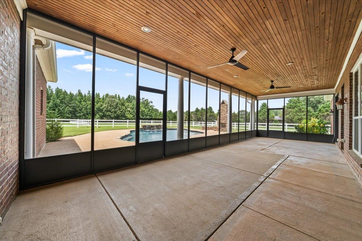 740 Frazier Road Rossville, TN 38066 - Photo 28 of 40 Expansive screened porch featuring a wood-panel ceiling, two ceiling fans, and concrete flooring