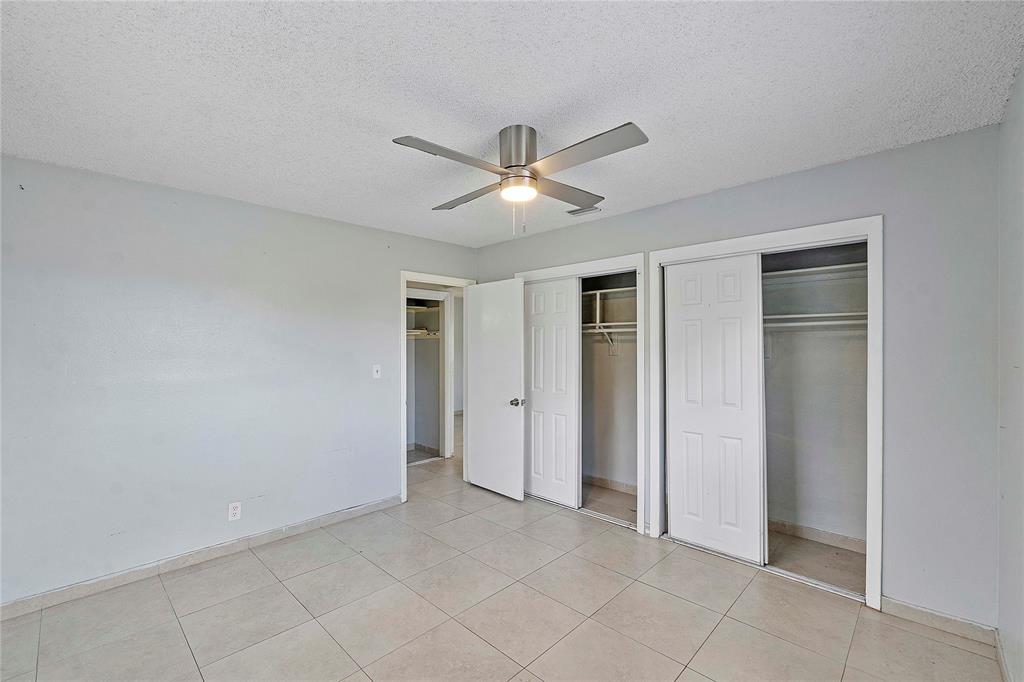 395 Southwest 15th Street, Unit 10 Pompano Beach, FL 33060 - Photo 6 of 14 a view of a livingroom with a ceiling fan and carpet