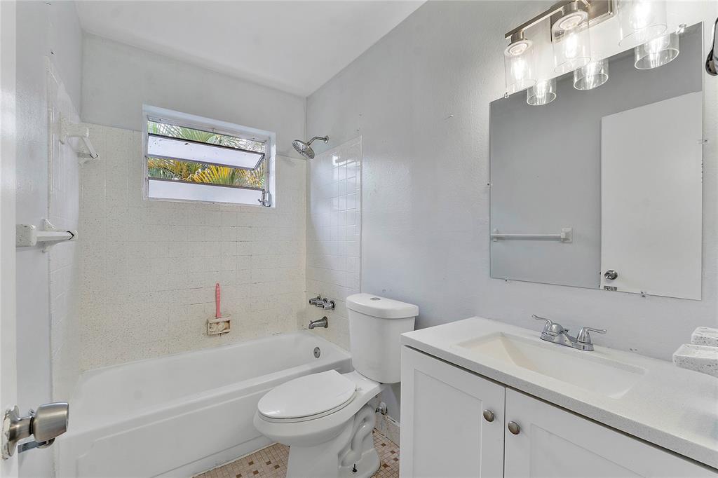 395 Southwest 15th Street, Unit 10 Pompano Beach, FL 33060 - Photo 7 of 14 a bathroom with a toilet a sink a mirror a bathtub and vanity