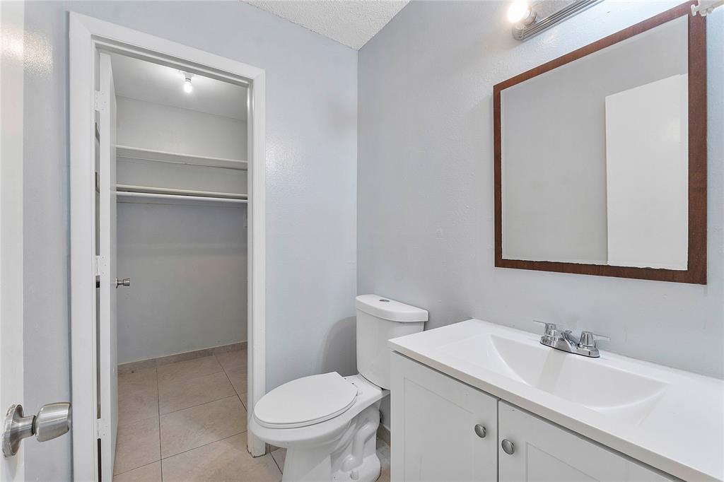 395 Southwest 15th Street, Unit 10 Pompano Beach, FL 33060 - Photo 8 of 14 a bathroom with a toilet sink and mirror