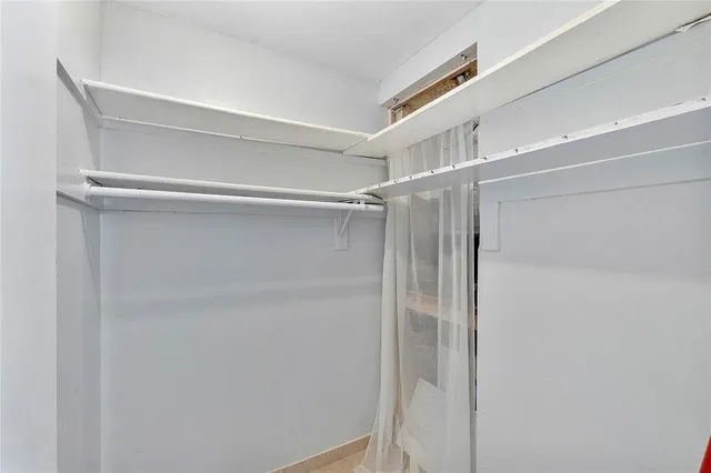 an empty room with a ceiling fan and carpet