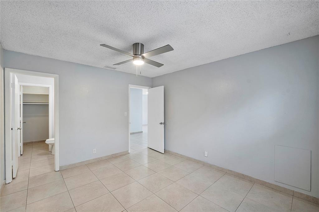395 Southwest 15th Street, Unit 10 Pompano Beach, FL 33060 - Photo 10 of 14 an empty room with a ceiling fan and carpet