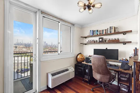 a view of a workspace with furniture and a window