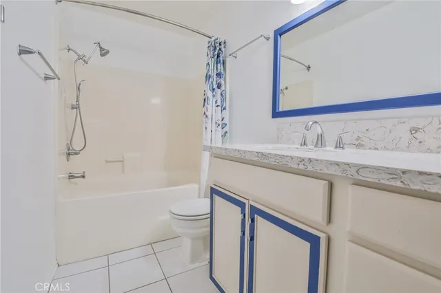 a bathroom with a granite countertop sink a toilet and shower