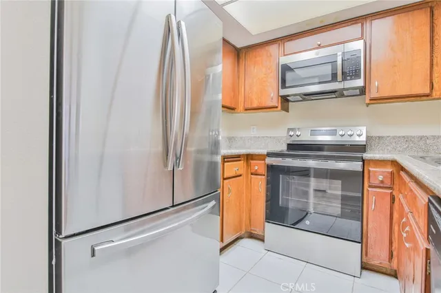 a kitchen with stainless steel appliances granite countertop cabinets and a window