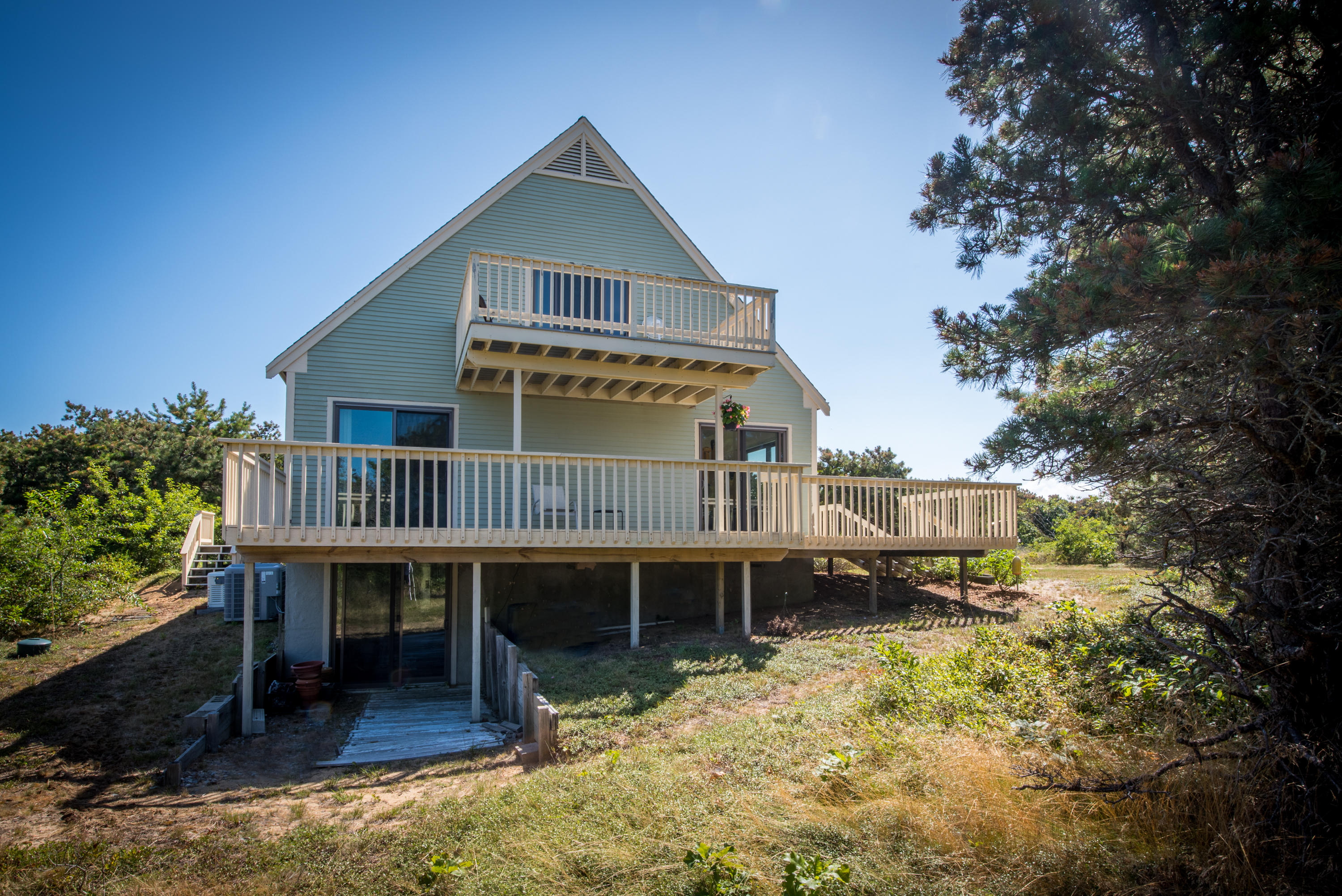 11 Pilgrim Pond Road Truro, MA 02666 - Photo 2 of 35 a view of a house with a wooden deck and a patio