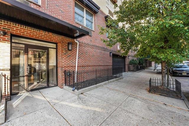 204 Grand Street, Unit 2C Hoboken, NJ 07030 - Photo 14 of 14 a view of a house with a tree and wooden fence