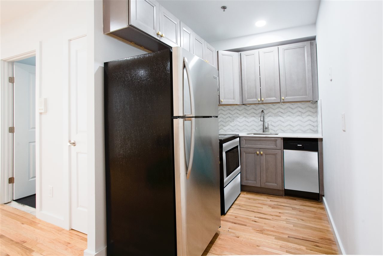 204 Grand Street, Unit 2C Hoboken, NJ 07030 - Photo 5 of 14 a kitchen with a refrigerator and a sink