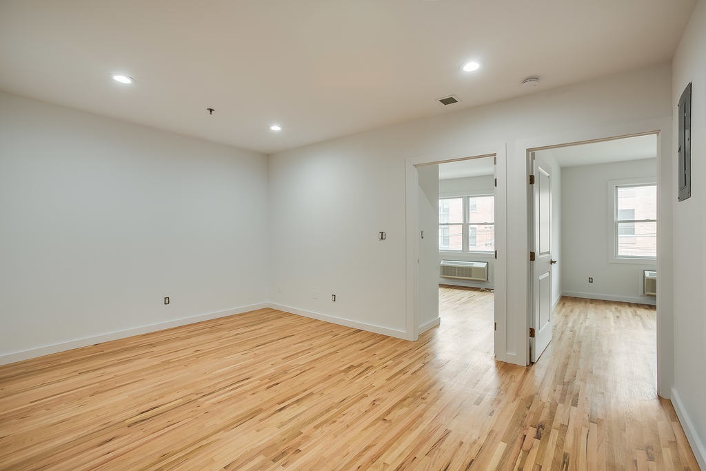 204 Grand Street, Unit 2C Hoboken, NJ 07030 - Photo 7 of 14 wooden floor in an empty room with a window