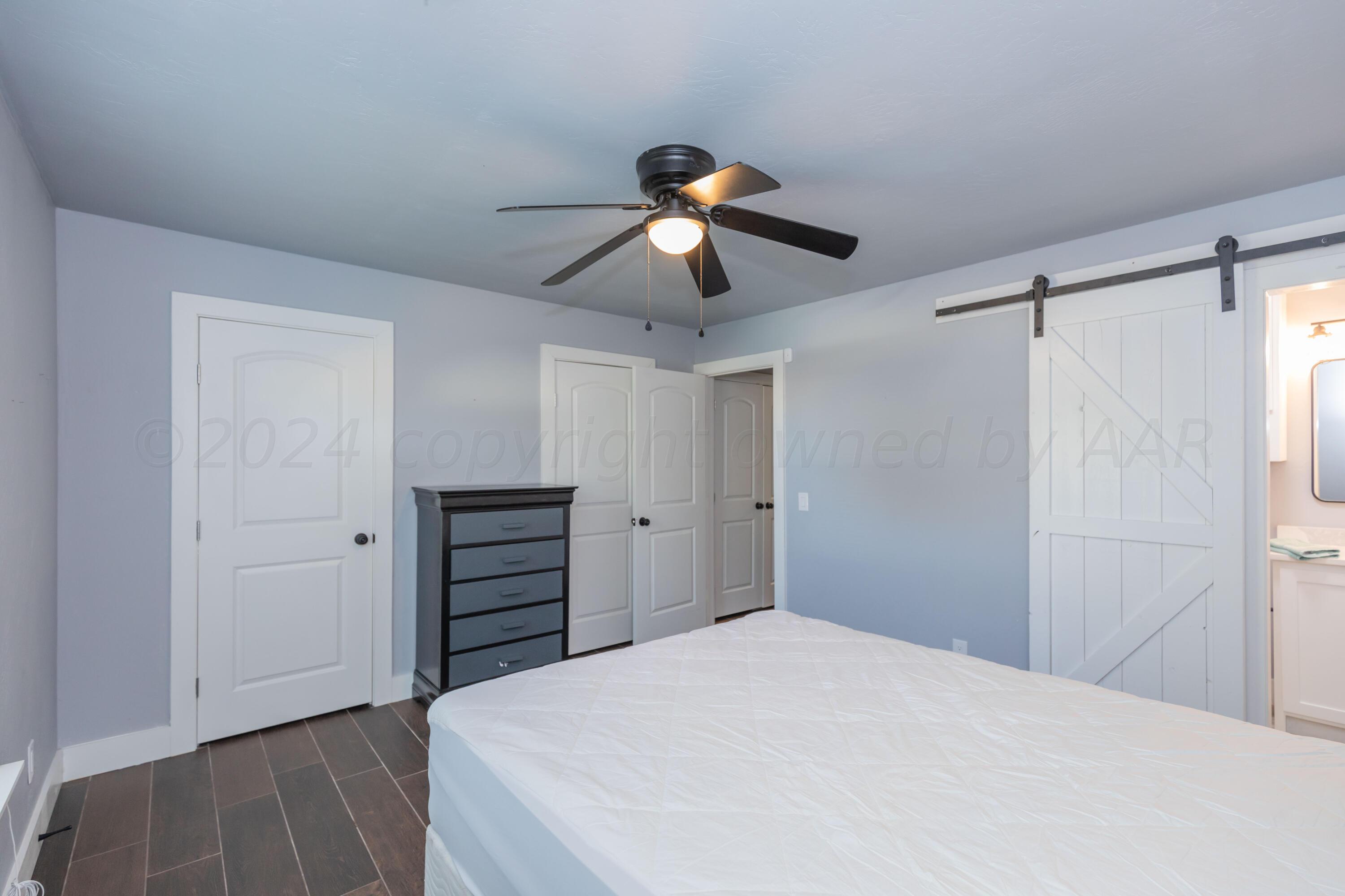 5101 McCarty Boulevard Amarillo, TX 79110 - Photo 8 of 20 a bedroom with a bed and a chandelier