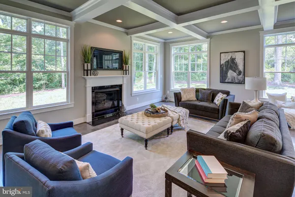 a living room with furniture fireplace and a large window