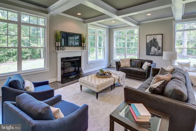 a living room with furniture fireplace and a large window