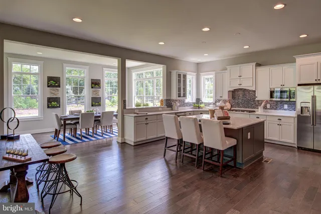 a kitchen with a dining table chairs and white appliances