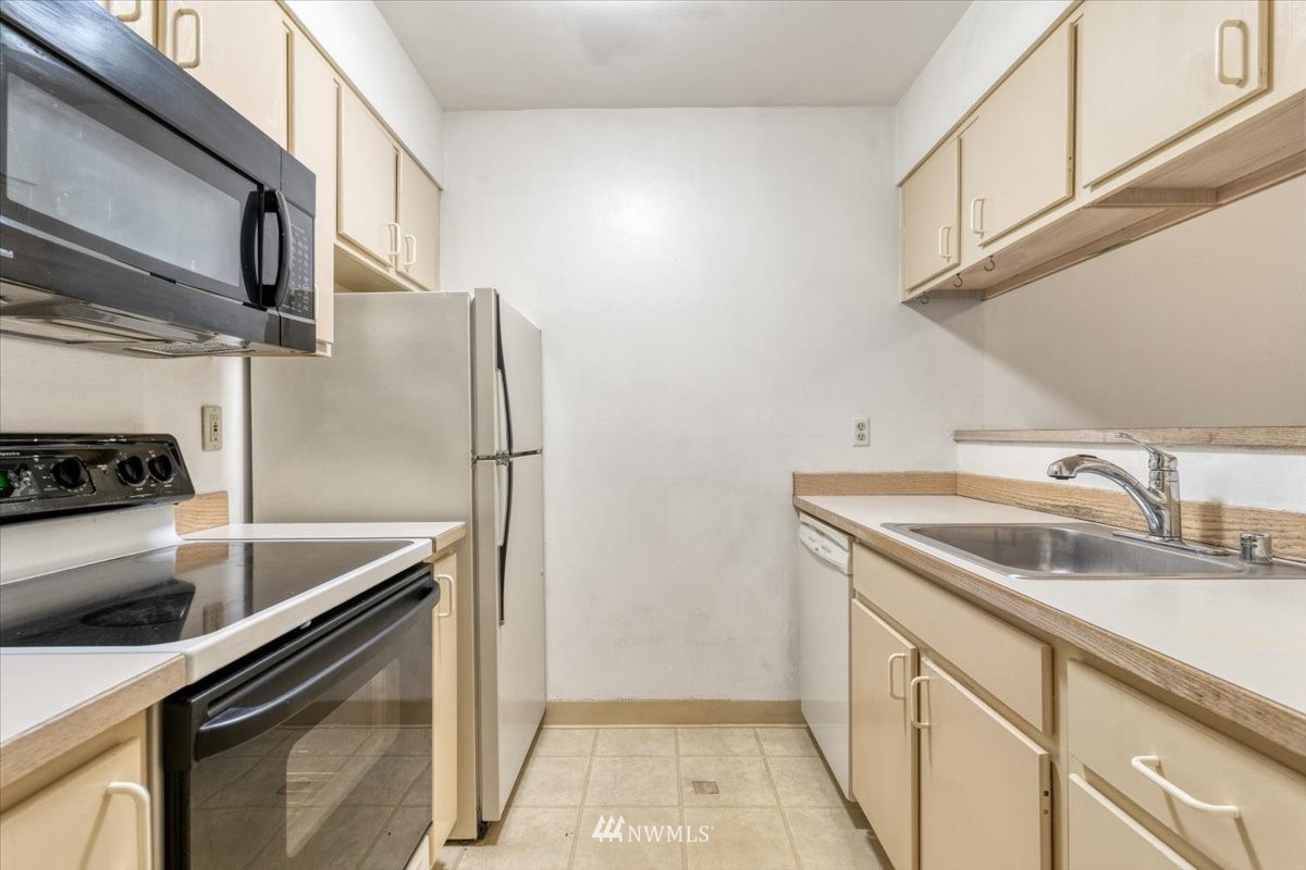 506 East Howell Street, Unit 108 Seattle, WA 98122 - Photo 4 of 20 a kitchen with stainless steel appliances granite countertop a sink and a refrigerator
