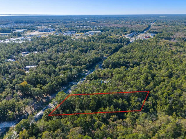 an aerial view of residential houses with outdoor space and trees