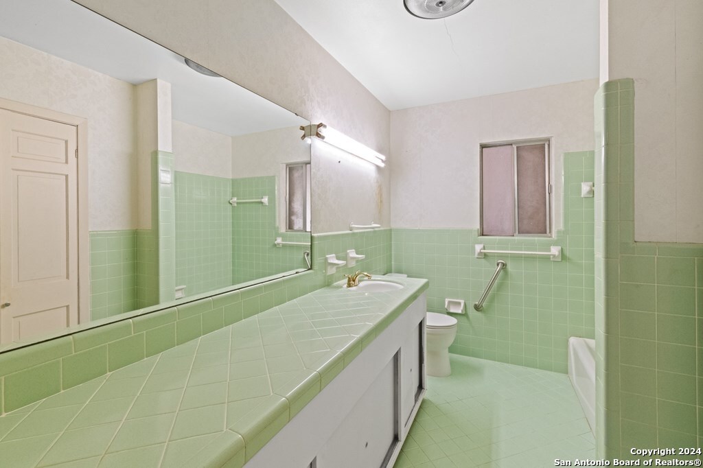 6268 Highway 27 Center Point, TX 78010 - Photo 16 of 39 a bathroom with a sink a toilet and mirror
