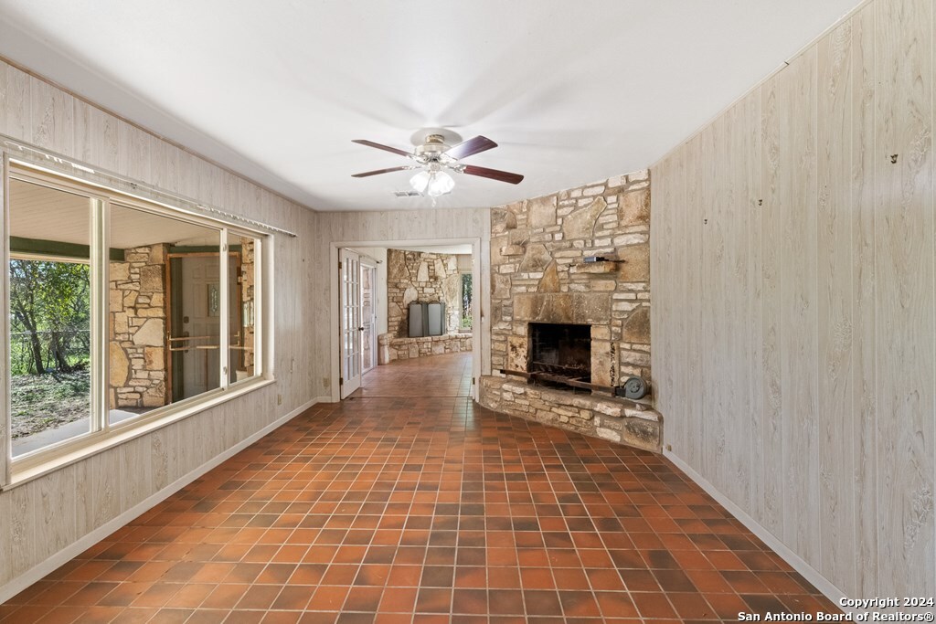 6268 Highway 27 Center Point, TX 78010 - Photo 18 of 39 a view of a livingroom with a fireplace a ceiling fan and windows
