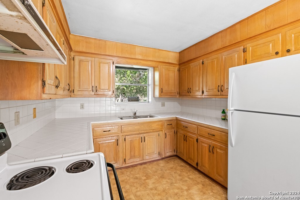 6268 Highway 27 Center Point, TX 78010 - Photo 25 of 39 a kitchen with a sink a refrigerator and a stove