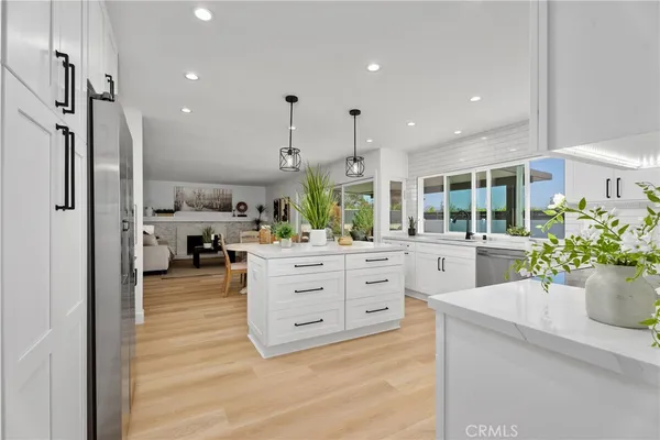 a kitchen with stainless steel appliances kitchen island granite countertop a sink a stove and cabinets