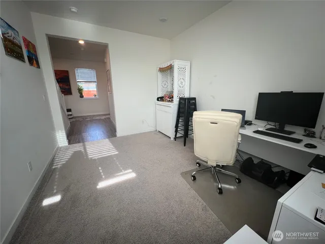 a view of a workspace with furniture and a window