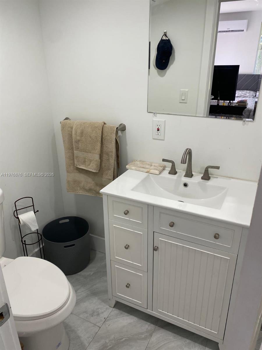 5710 Douglas Street Hollywood, FL 33021 - Photo 16 of 21 a bathroom with a toilet sink and mirror