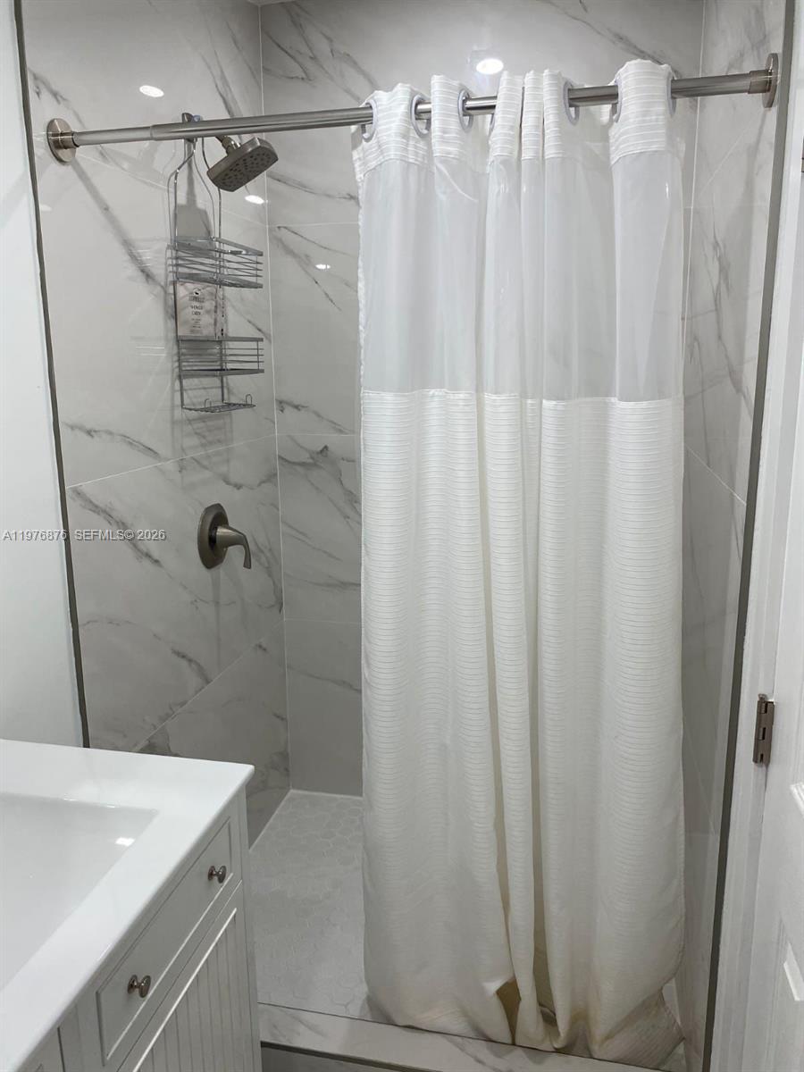 5710 Douglas Street Hollywood, FL 33021 - Photo 17 of 21 a bathroom with a shower curtain and sink