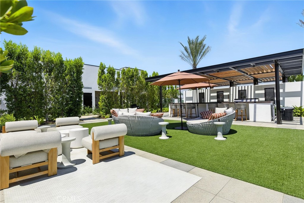 615 Sage Way Montebello, CA 90640 - Photo 20 of 23 a view of a patio with table and chairs under an umbrella with a fire pit
