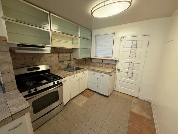 a kitchen with a stove cabinets and a sink