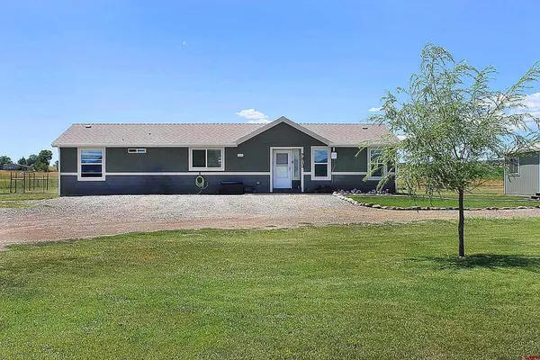 a front view of a house with a yard and trees
