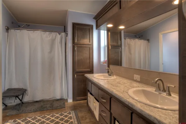 a bathroom with double vanity and a mirror