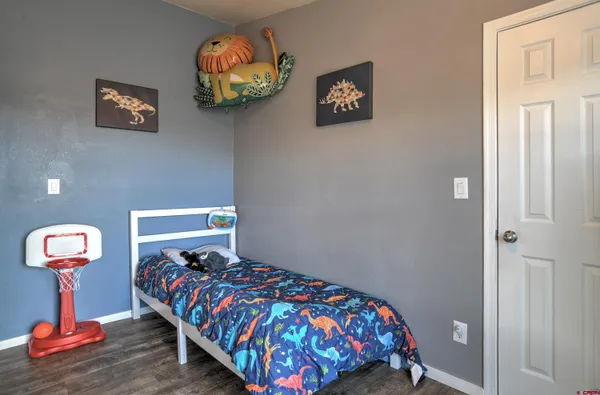 a bedroom with a bed and a lamp on dresser