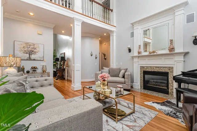 a living room with fireplace furniture a flat screen tv and a large window