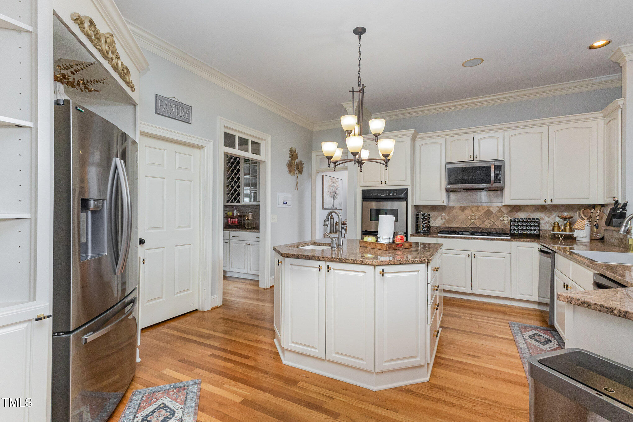 12617 Richmond Run Drive Raleigh, NC 27614 - Photo 18 of 77 a kitchen with stainless steel appliances granite countertop a refrigerator a stove top oven and a chandelier