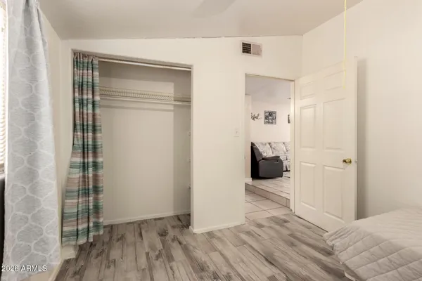 a bedroom with a bed and a wooden floor