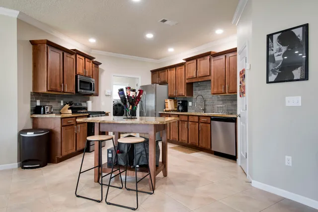 a living room with furniture a flat screen tv and kitchen view
